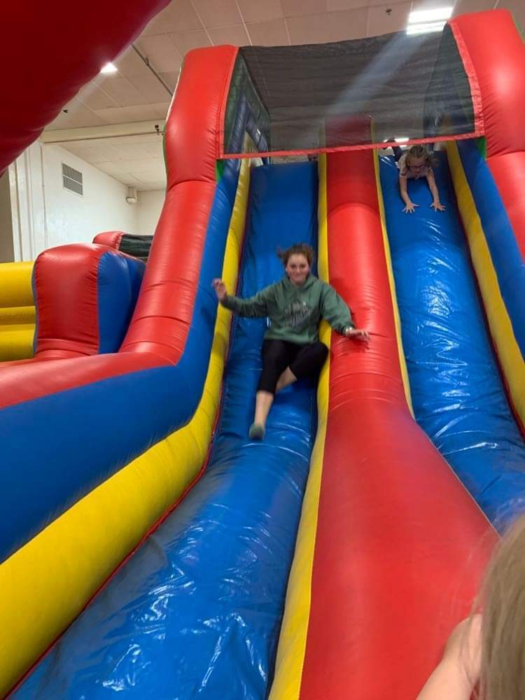 students sliding on the inflatable slide