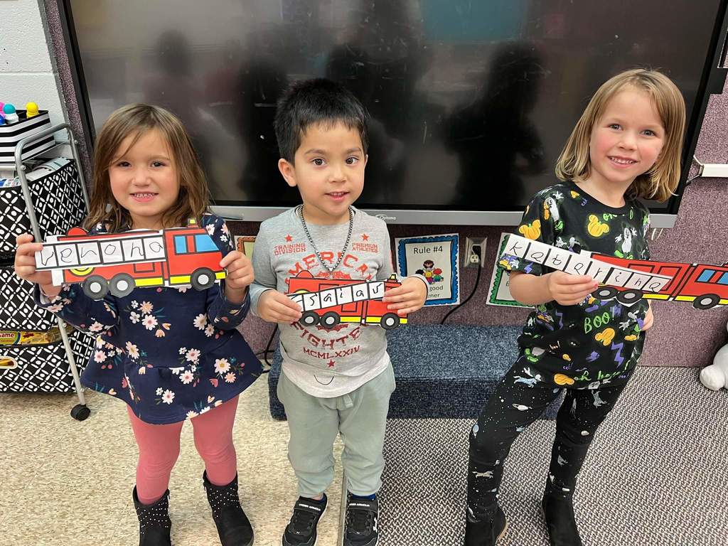 3 kids sharing their firetrucks
