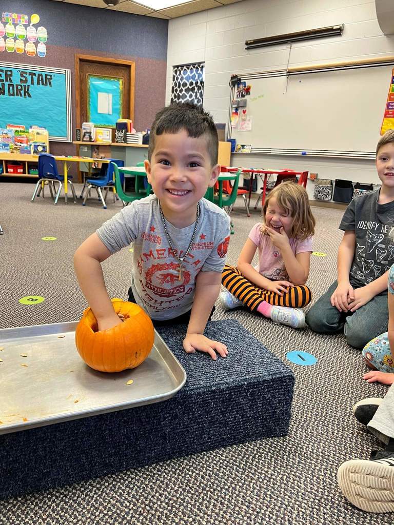 A student feeling the inside of the pumpkin.