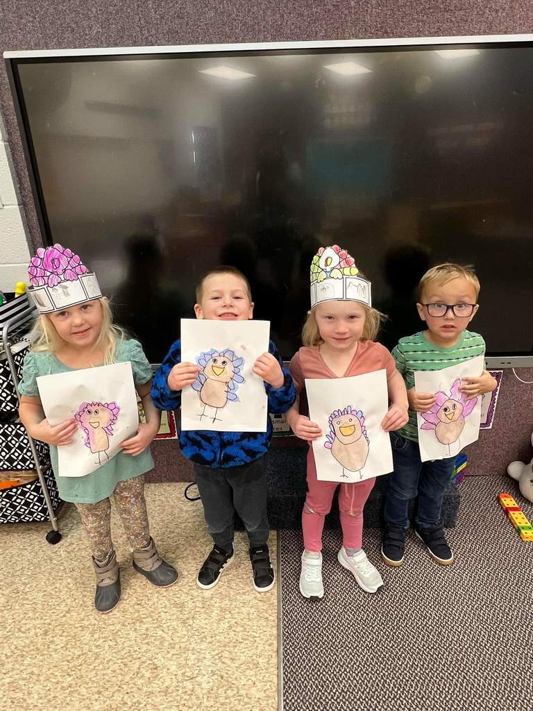 Two boys and two girls with their turkey drawings.