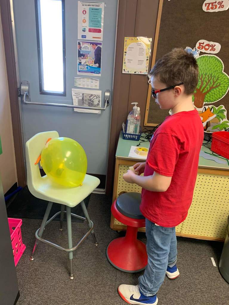 A student looking at his balloon to decide what to do.