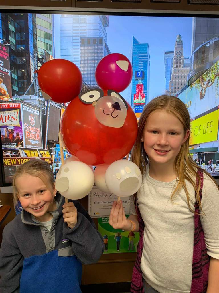 Two girls holding their balloon animal.
