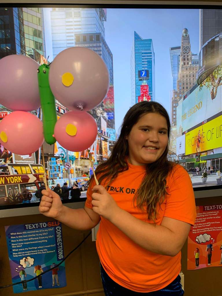 A girl holding her butterfly balloon.