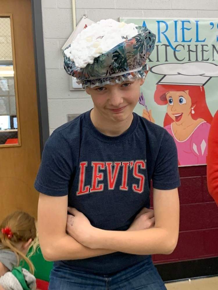 A student with shaving cream on his head.