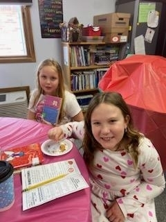 students eating and sharing books