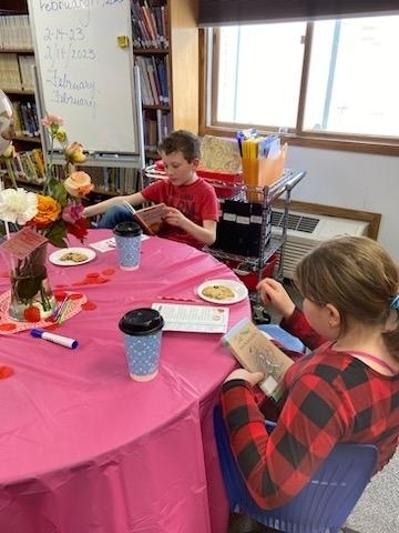Kids reading books and eating snacks