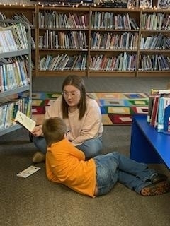 a para reading books to a student