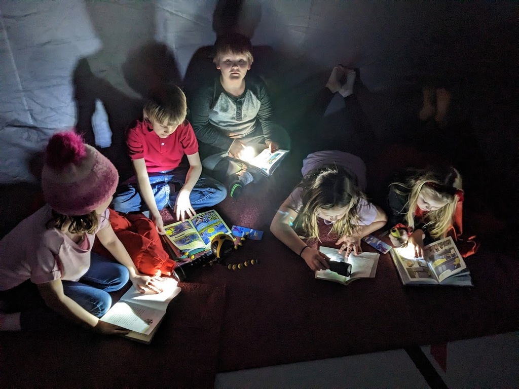 kids reading with flashlights