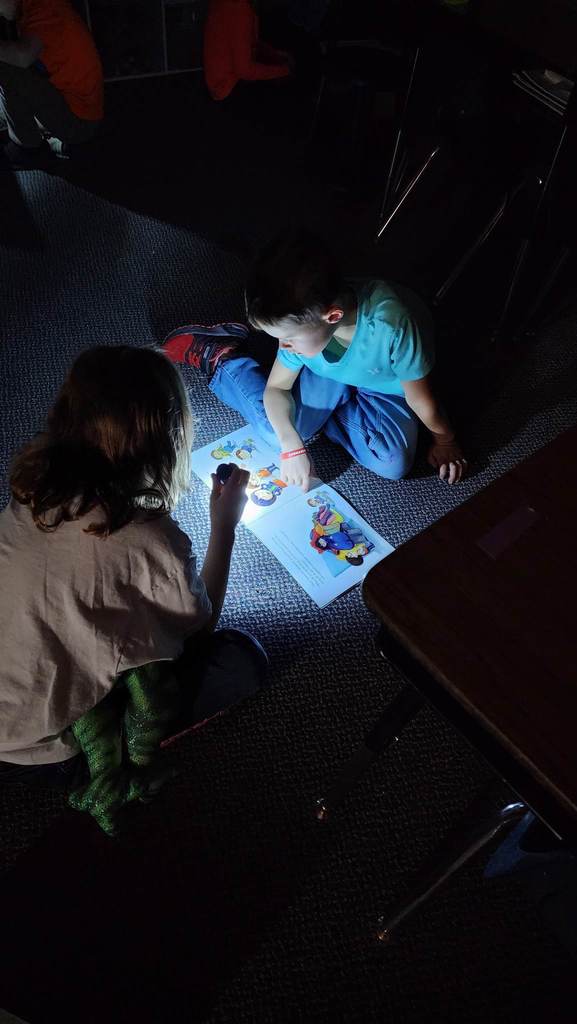 students reading with flashlights