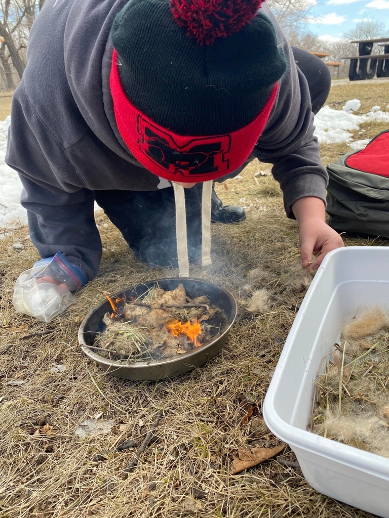 a boy getting the fire started