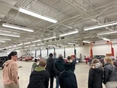 students looking at auto showroom