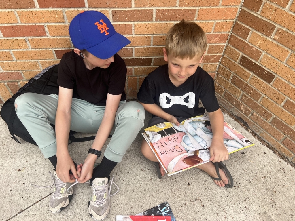 2 boys reading a book.