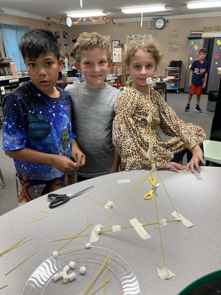 3 kids building their spaghetti tower